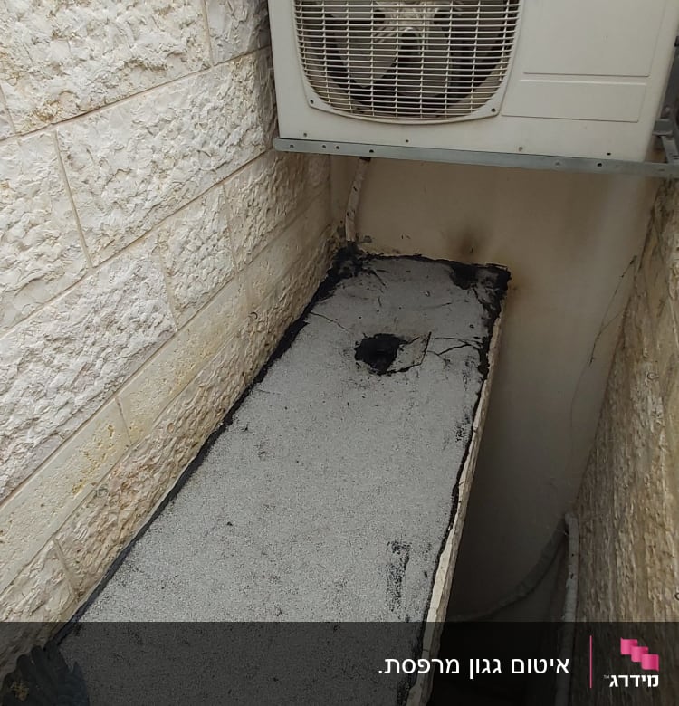 איטום גג עם חומר שחור ליד מזגן